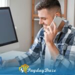 A man sitting in front of a computer calling an onloine lender to get a payday loan without proof of income