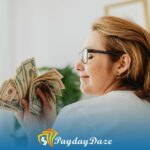 A woman in glasses holding a stack of money wondering if they can return the loan if they don't use it