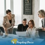 A group of people sitting around a table to compare small loans