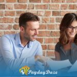 A man and a woman sitting on a couch looking at a piece of paper containing details on improving your chances of getting a payday loan