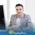 A man sitting at a desk in front of a computer considering payday loans in Los Angeles