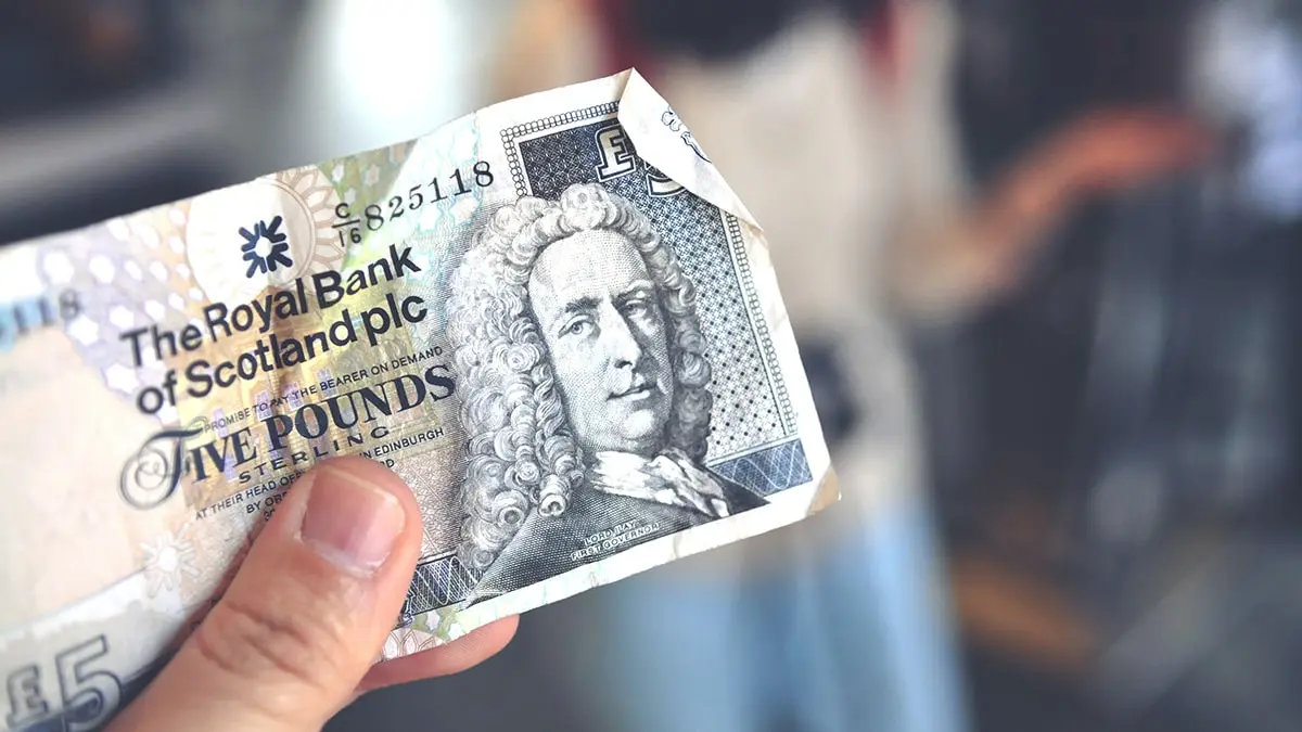 a person holding a bank note in their hand