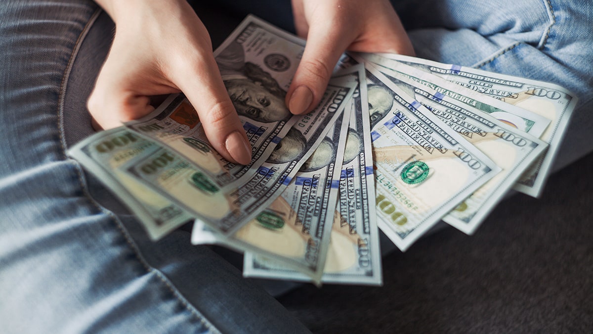 a person sitting on a couch holding a bunch of money