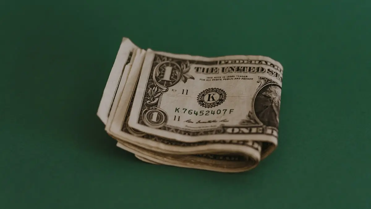 a stack of money sitting on top of a green table