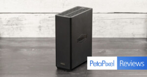 A black external hard drive sits on a wooden table against a white-washed wooden backdrop. The hard drive has the logo "TerraMaster" printed on it. A banner at the bottom reads "PetaPixel Reviews" in blue and white text.