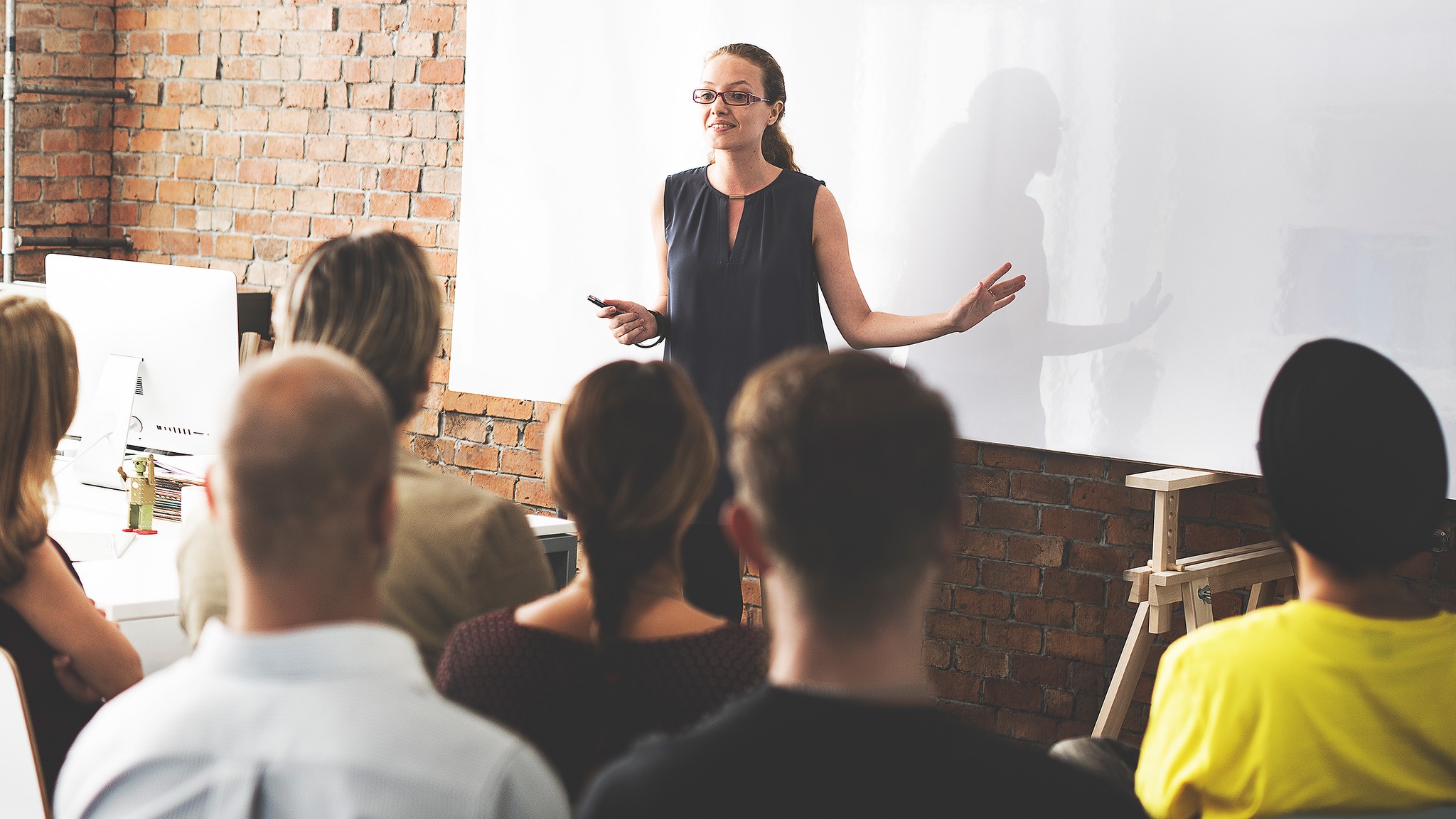 a woman giving a presentation to a group of people.