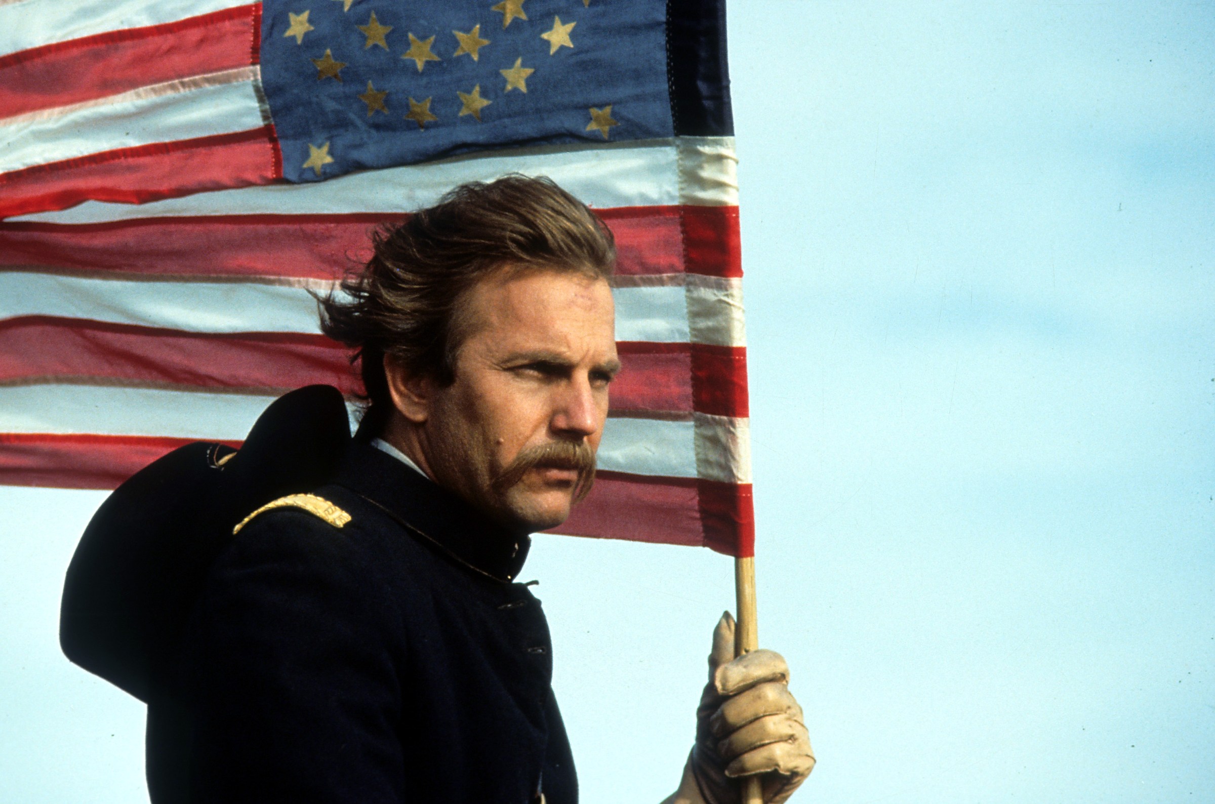 Kevin Costner holding an American flag in Dances With Wolves.