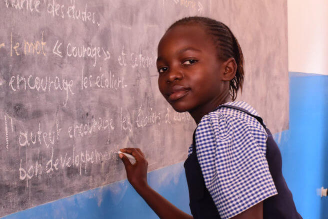 Malaika - Smiling Girl at Chalkboard