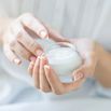 Beautiful woman hands applying moisturizer