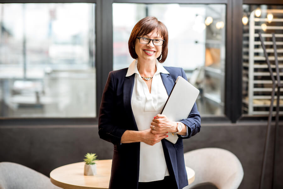 Smiling business owner holding laptop