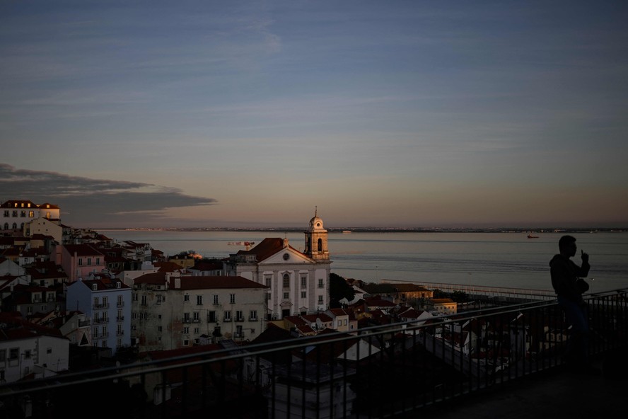 Turista posa para foto no mirante Portas do Sol, em Lisboa