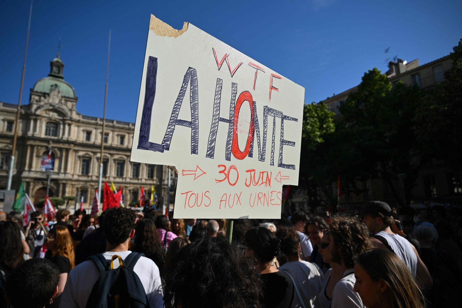 Um manifestante segura um cartaz que diz "Vergonha! Todos às urnas em 30 de junho" durante uma manifestação contra o partido francês de extrema direita "Rassemblement National" (RN) em Marselha, sul da França. — Foto: Nicolas TUCAT/AFP