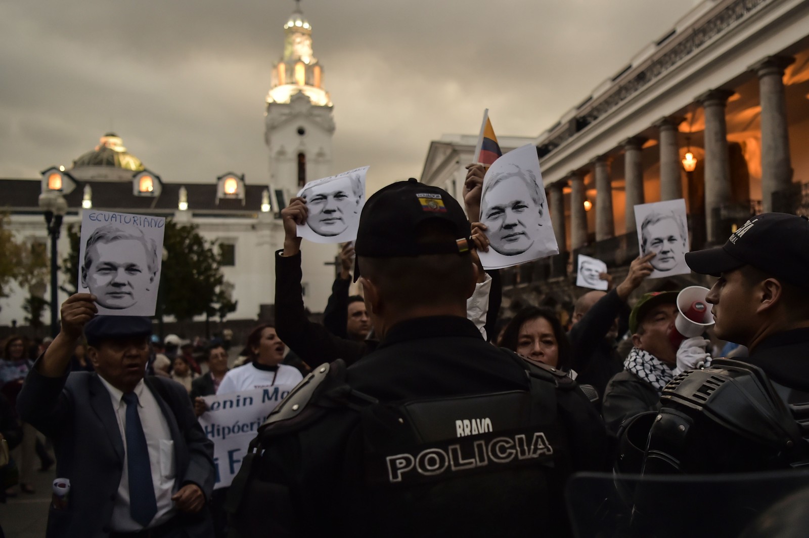 Policiais montam guarda enquanto apoiadores do ex-presidente equatoriano Rafael Correa participam de uma manifestação em frente ao palácio presidencial Carondelet, em Quito, para mostrar seu apoio ao fundador do WikiLeaks, o australiano Julian Assange, um refugiado na Embaixada de Quito em Londres, em 2018 — Foto: RODRIGO BUENDIA/AFP
