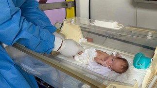 Bebê palestino é elevado por médicos egípcios em ambulância após ataque a hospital — Foto: AFP