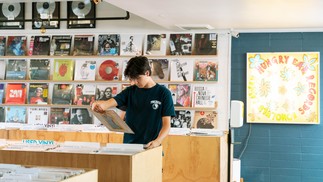 Cliente pesquisa um LP na loja de discos Hungry Ear, em Honolulu, uma das mais antigas do Havaí e a preferida de Jack Johnson — Foto: Michelle Mishina Kunz/The New York Times