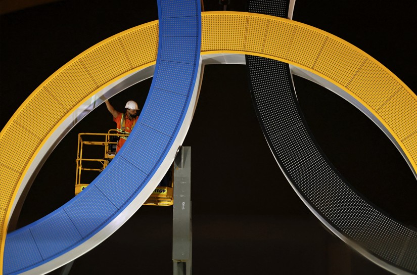 Instalação dos anéis olímpicos na Torre Eiffel — Foto: AFP
