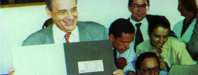 O então ministro da Fazenda Fernando Henrique Cardoso, em seu último dia no posto, apresenta as cédulas de real. Fernando Henrique deixou o cargo para se candidatar à presidência e, graças à popularidade do plano, foi eleito.  — Foto: Arquivo - 30/04/1994