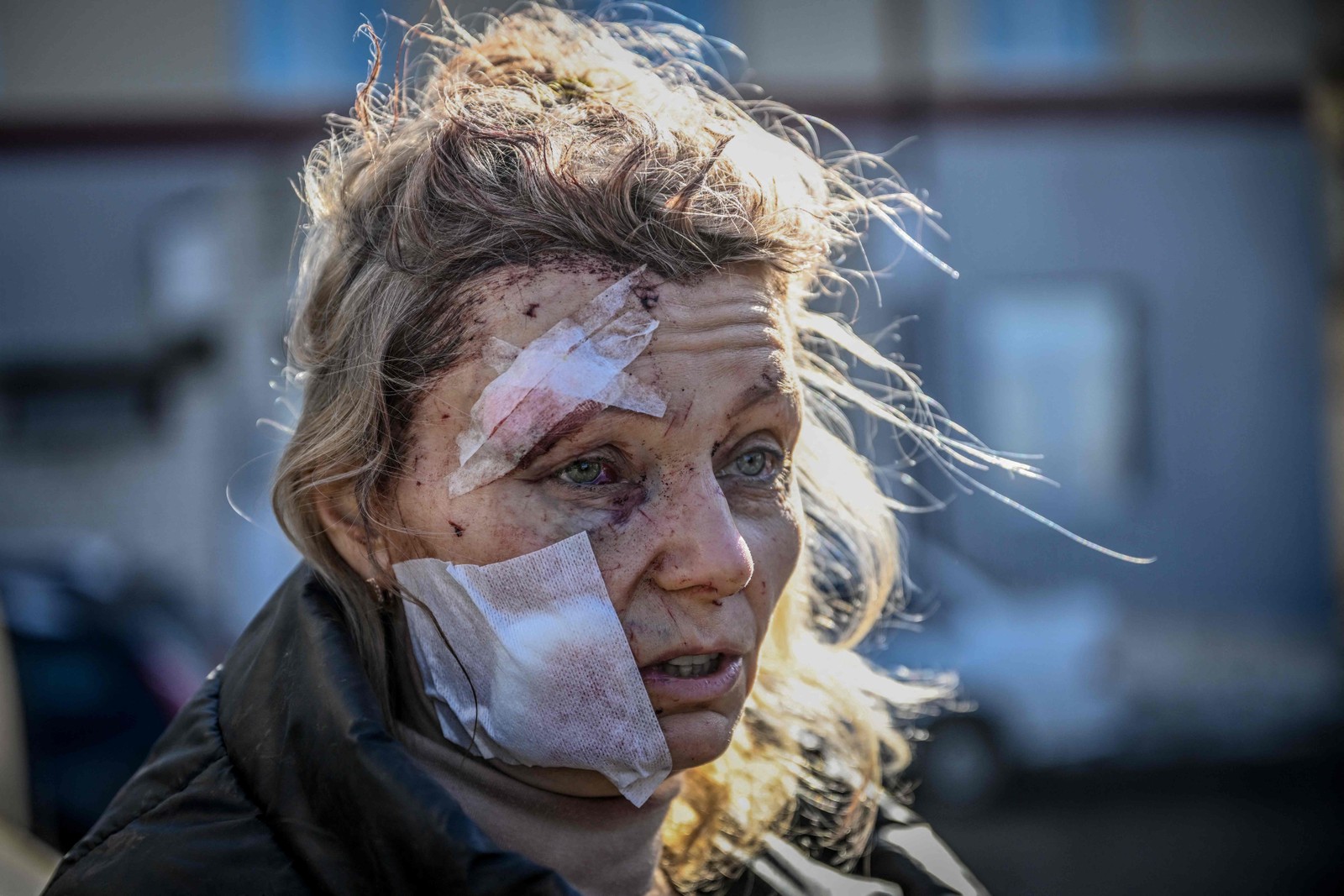 A professora Olena Kurylo, de 52 anos, aguarda por atendimento em frente a um hospital em Chuguiv — Foto: Aris Messinis / AFP