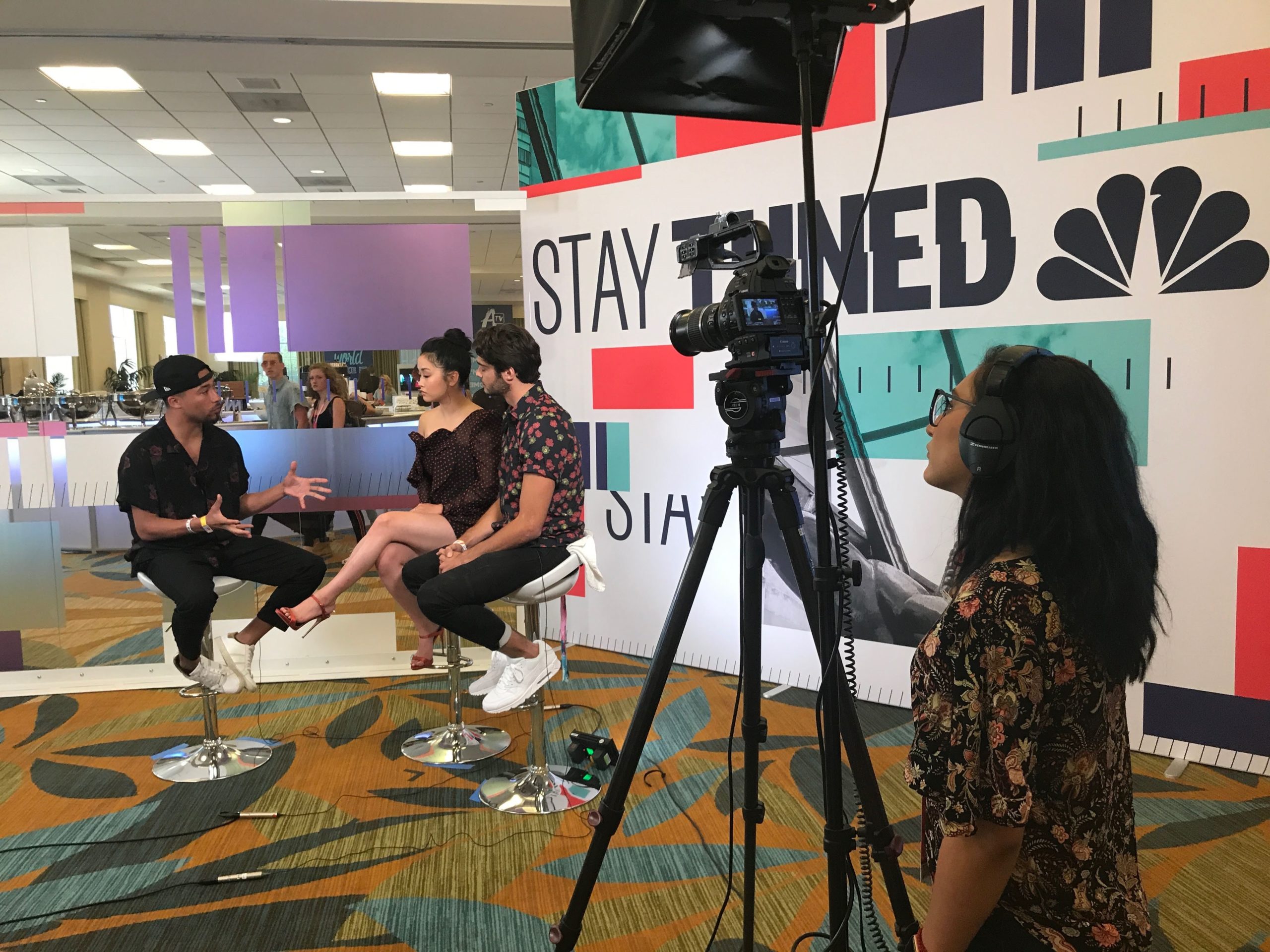 Photo of the intern Samantha Avalos working behind the camera to record an interview for the news with three people in the video