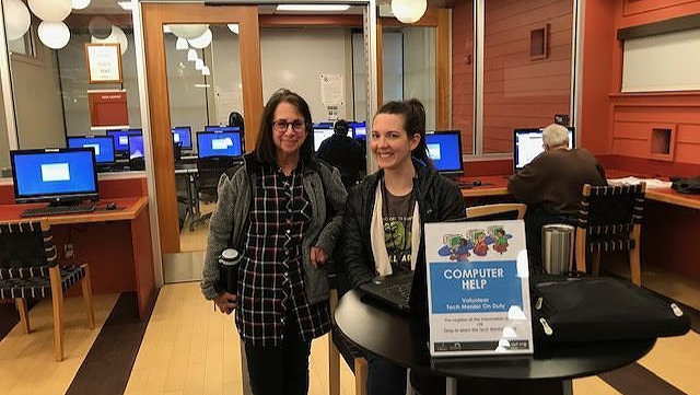 Two friendly tech mentors in computer lab.