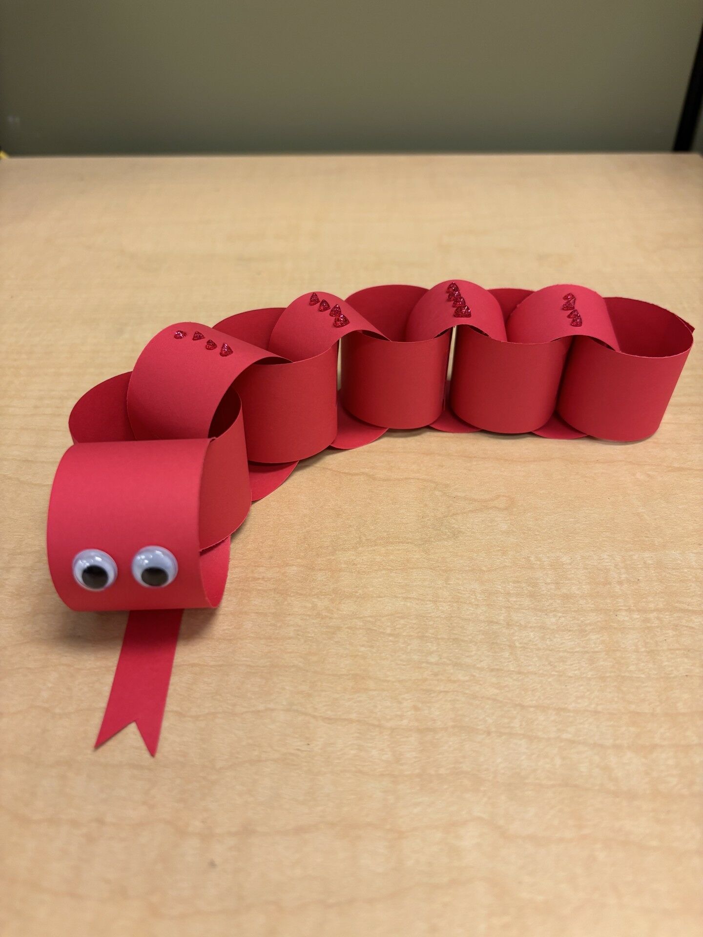 Red construction paper snake chain with googly eyes.