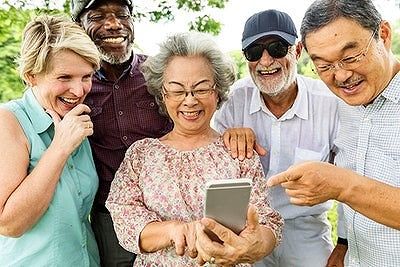 group of adults around a tech device