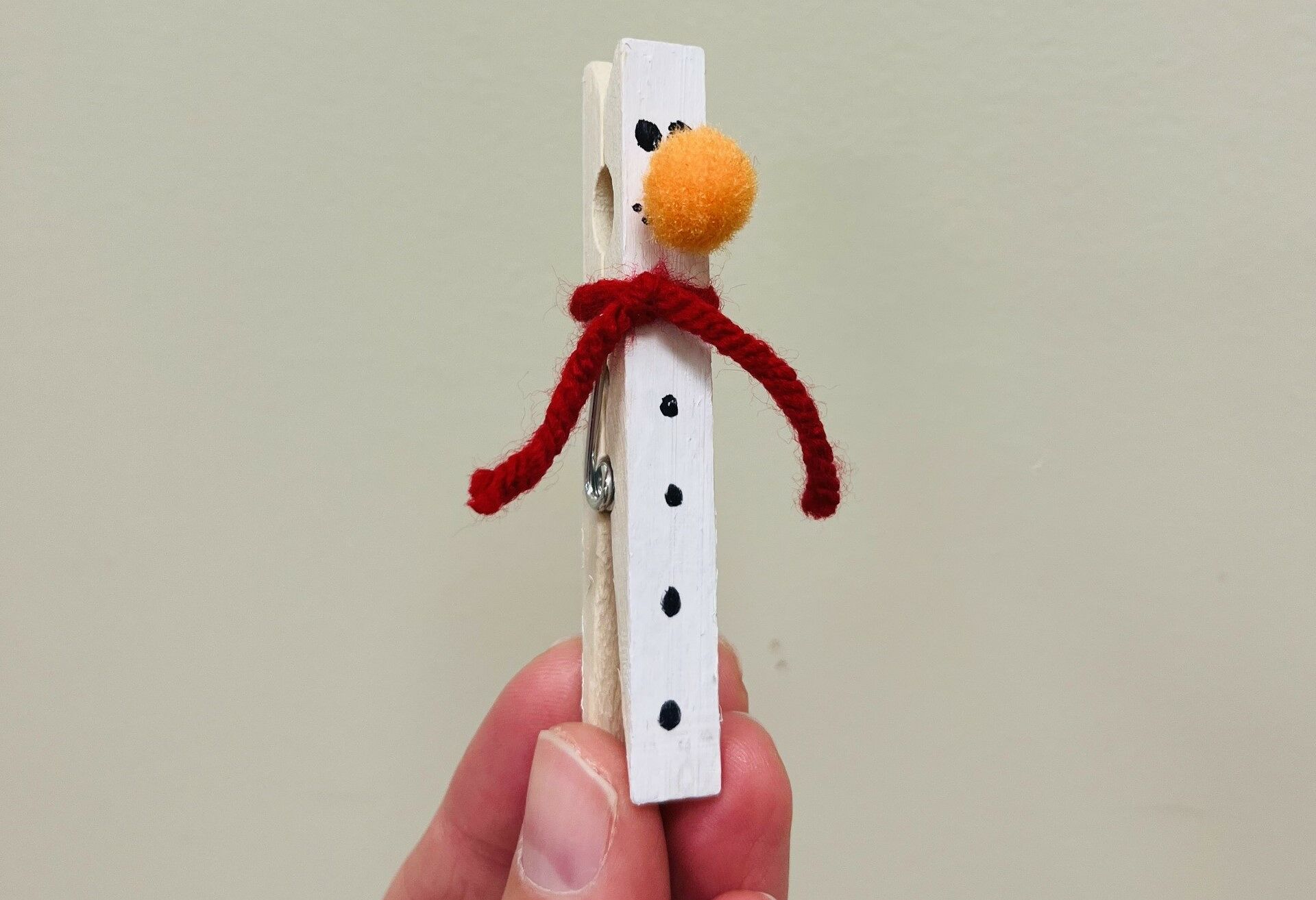 A wooden clothespin painted to look like a snowman.