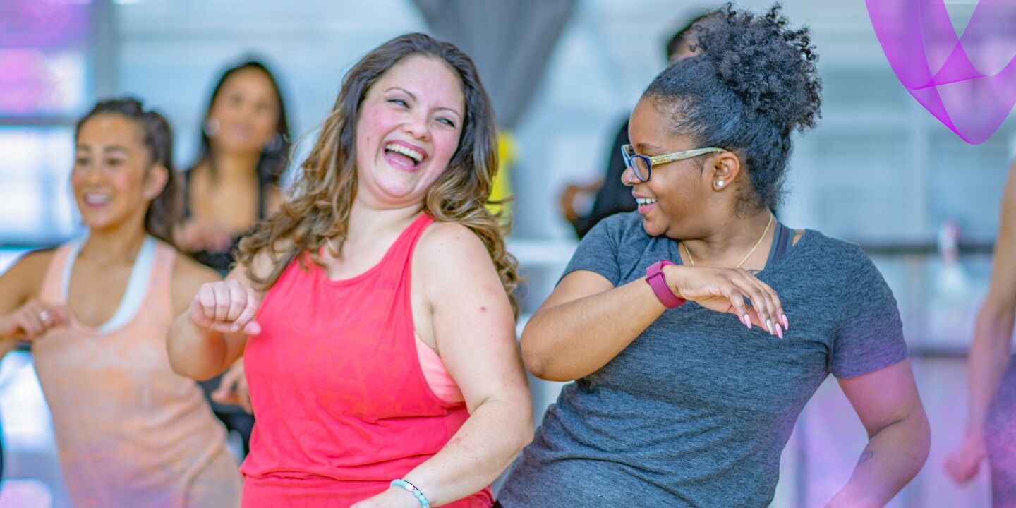 Women dancing and smiling in a class together.