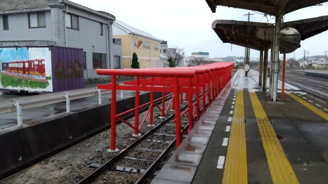 The Japanese train station with torii gates on its tracks