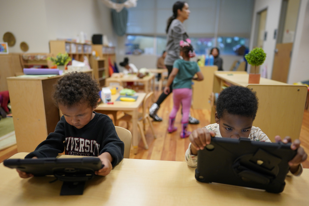 children work on tablets.