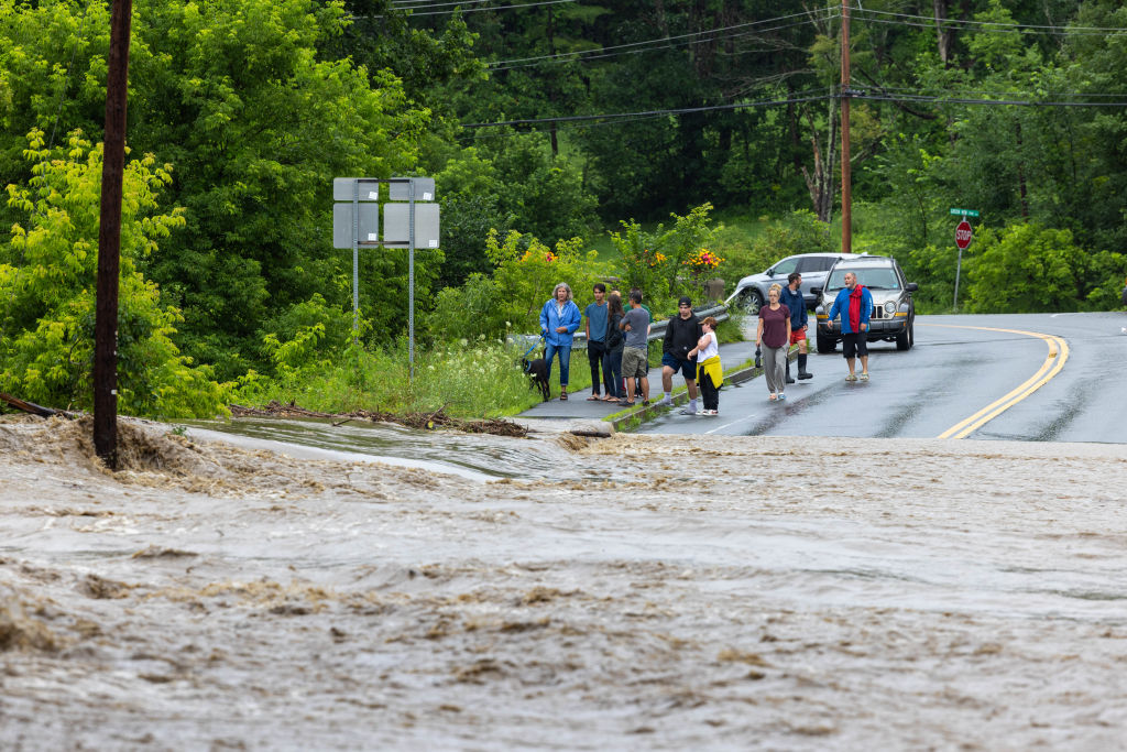 People look at a flooded road in Vermont.