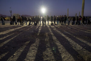 Immigrants line up at a remote U.S. Border Patrol processing center.