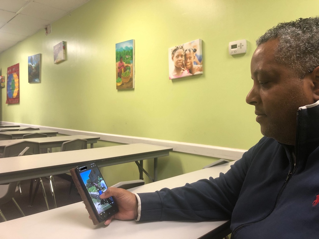 A man displays photos on a cellphone.