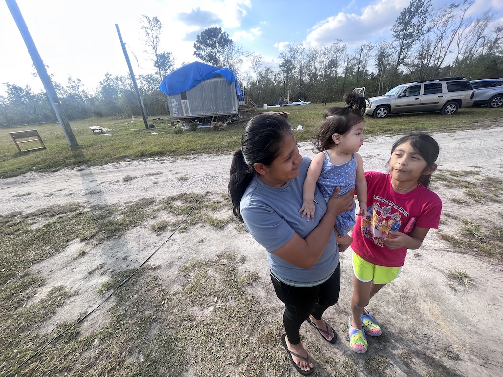 A woman holds a small child.