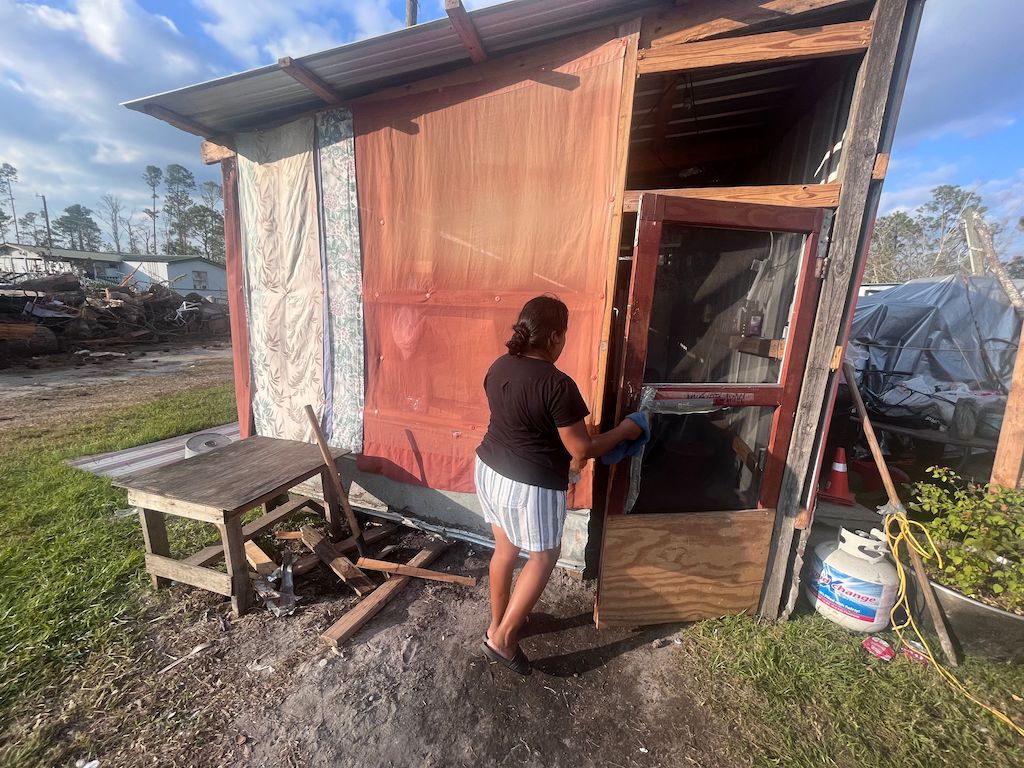 A woman enters a makeshift shelter.