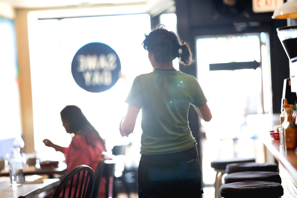 A server waits on customers at a café.