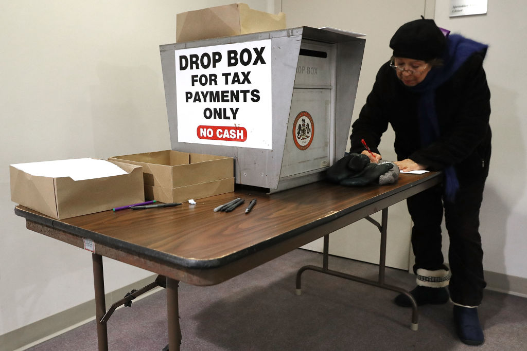 A person uses a drop box to pay their property taxes.