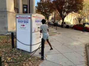 A voter in Washington, D.C., brings her ballot to a drop box.