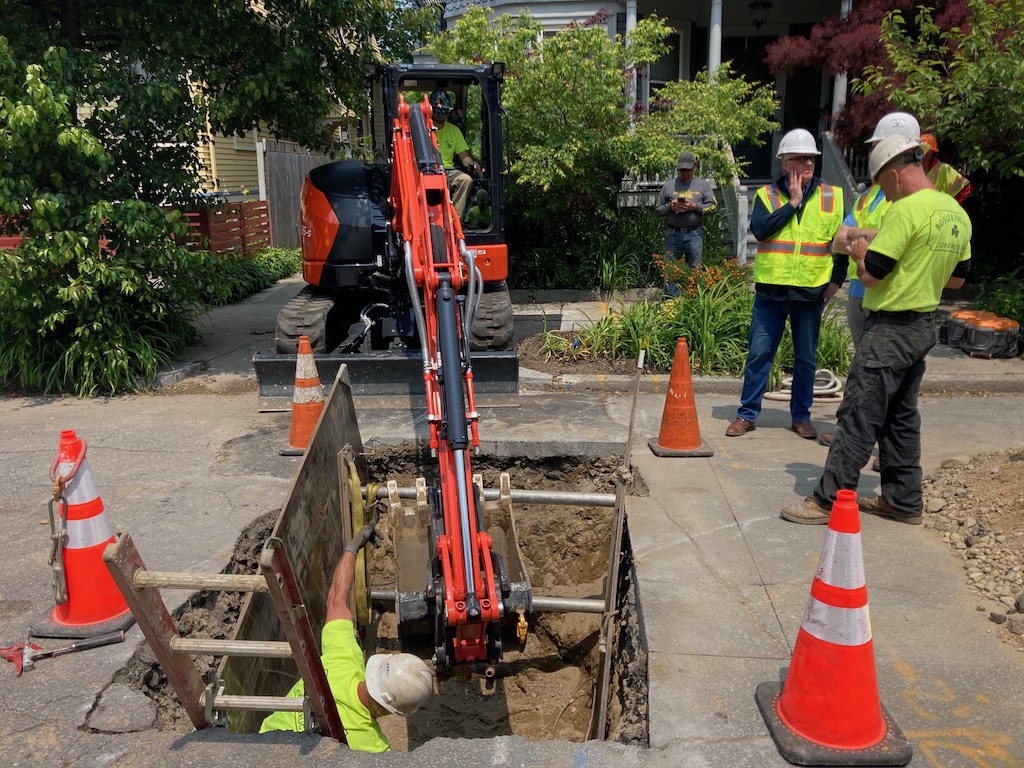 Workers remove a lead service line.