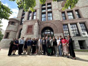 A group poses for a photo outside a courthouse.