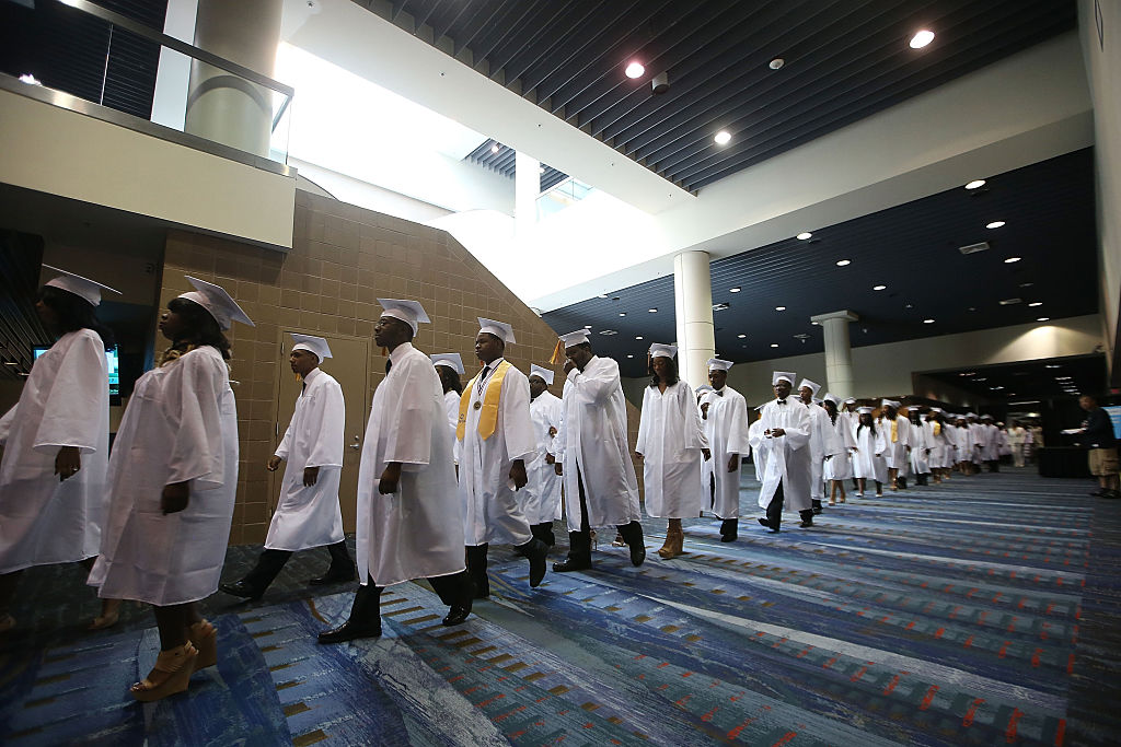 High school graduates walk at their commencement.