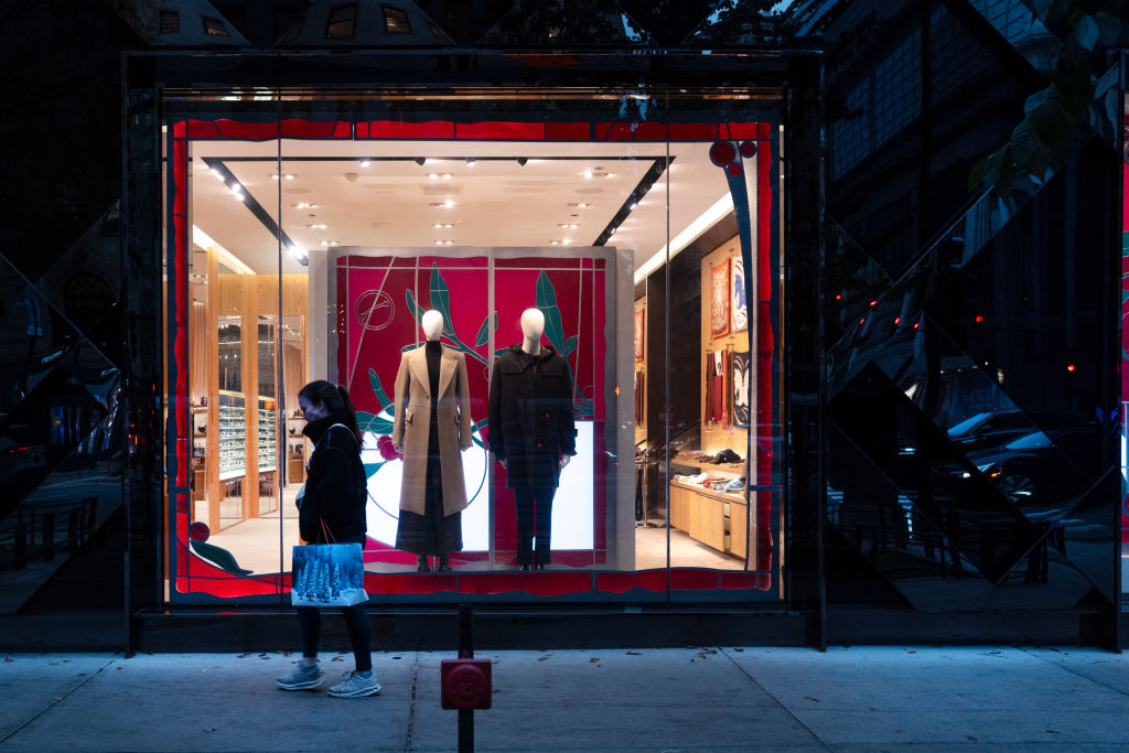 A woman walks past a store window in Chicago.