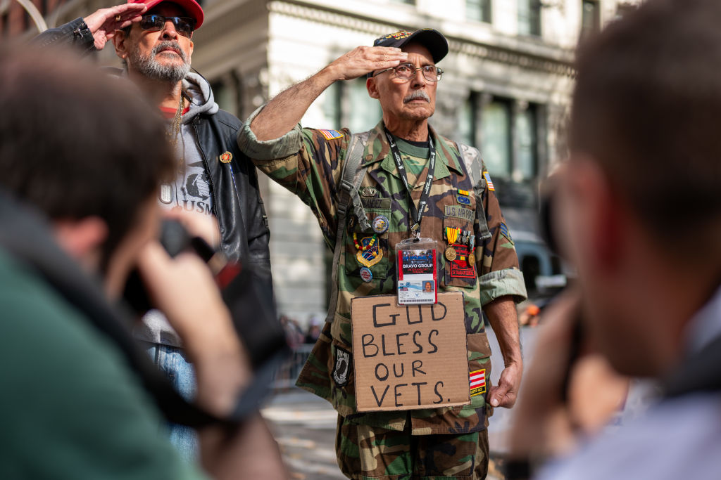 Two men salute while participating in New York City's Veterans Day parade.