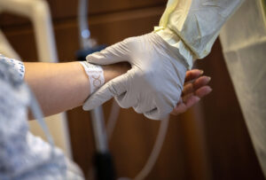 A health worker holds a patient's arm.