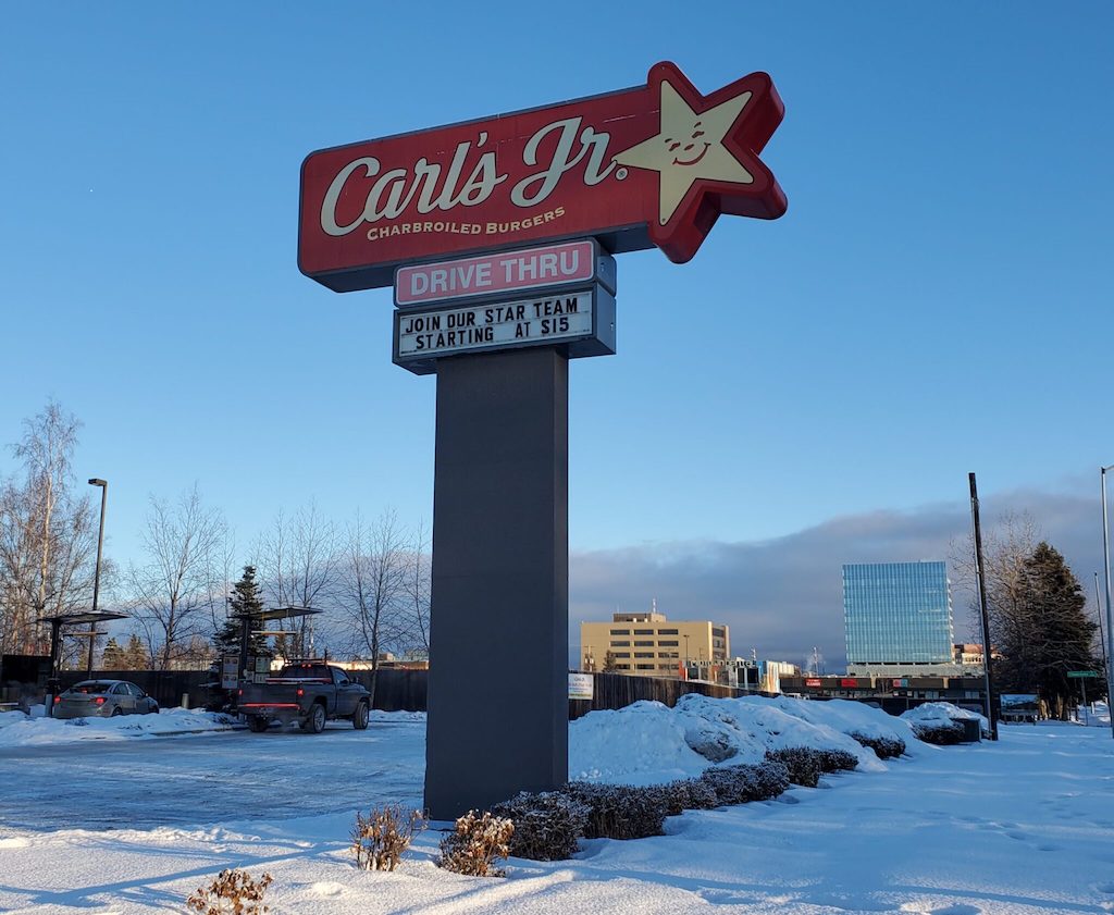 A sign at a fast-food restaurant advertises for workers.