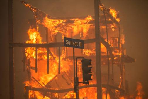 Flames from the Palisades Fire burn a building on Sunset Boulevard