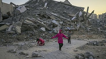 Palestinian children play next to a building destroyed by Israeli army strikes in Khan Younès, in the Gaza Strip, on 1 January 2025.