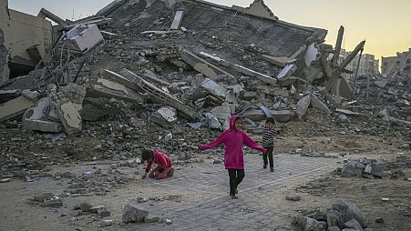 Palestinian children play next to a building destroyed by Israeli army strikes in Khan Younès, in the Gaza Strip, on 1 January 2025.