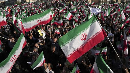 Pro-government demonstrators wave Iranian flags during their rally condemning recent anti-government protests over the death of Mahsa Amini, 25 September, 2022