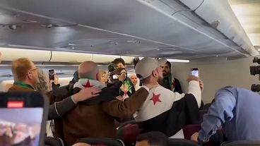 Syrische Passagiere singen an Bord des ersten Qatar-Airways-Flugs nach Damaskus seit Assads Abgang